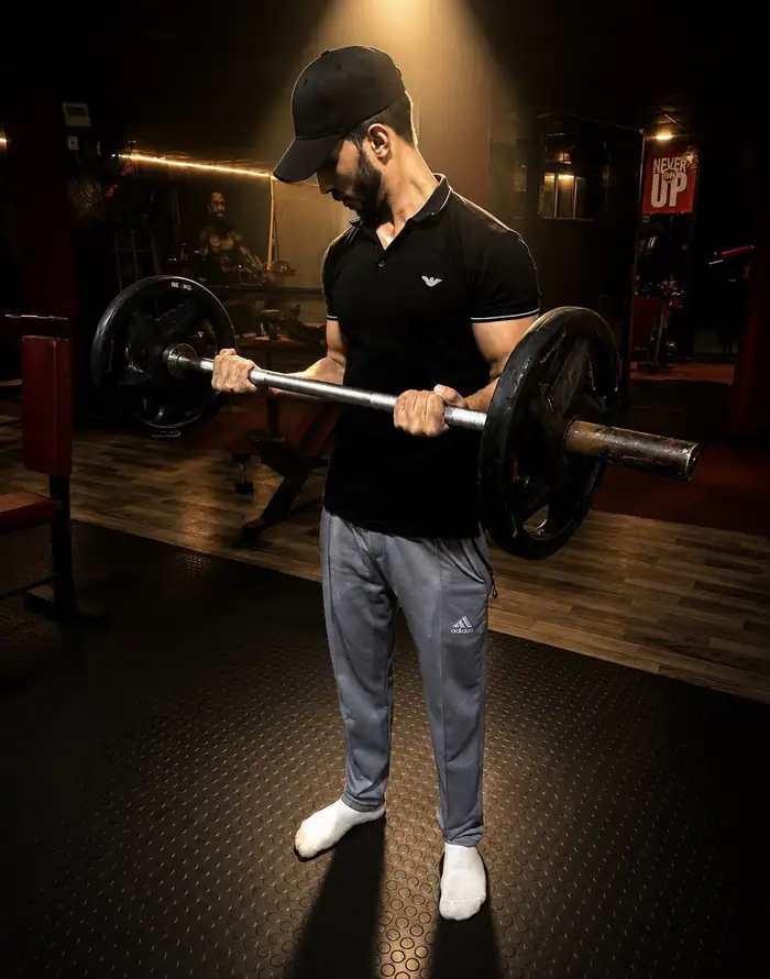 Mohfit member performing a barbell curl